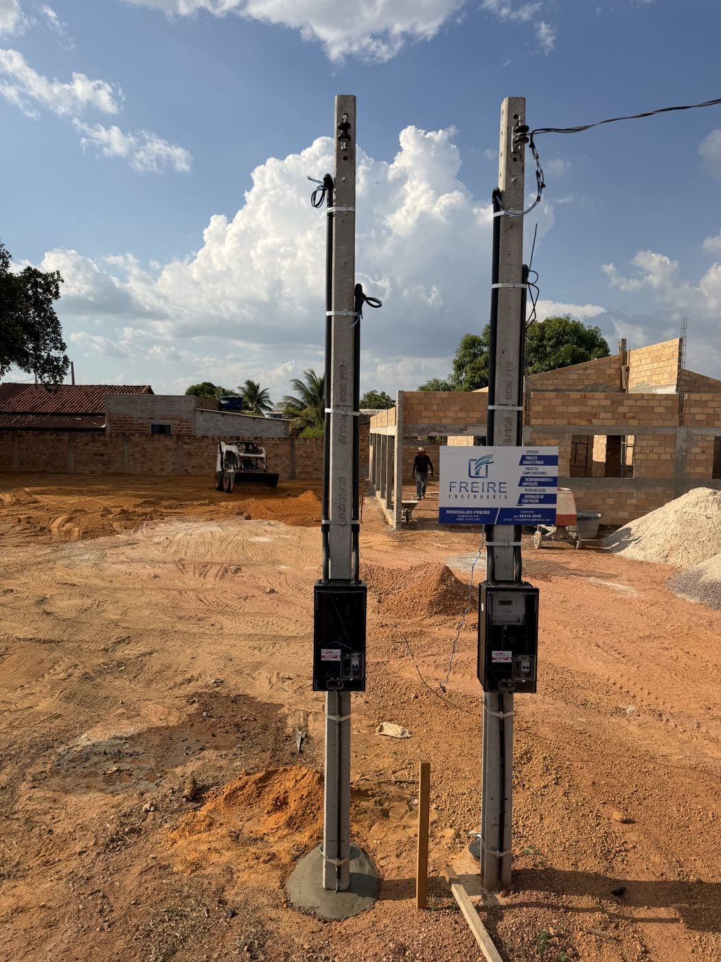 Dois postes de concreto com caixas de medição instalados em obra